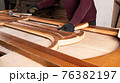 the master is engaged in the restoration of the wooden door in the workshop 76382197