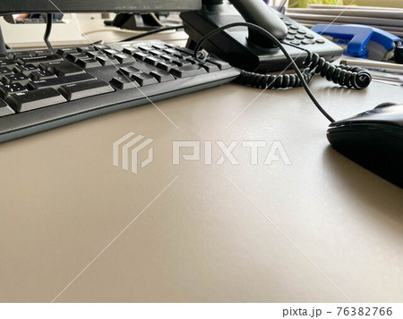 Black modern computer mouse keyboard and telephone on a working office table in a business company 76382766