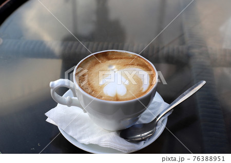 a glass of coffee on a table in a restaurant	 76388951