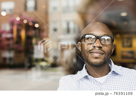 Black man looking out window 76391109