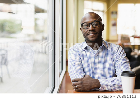 Black man having cup of coffee in cafe Black man having cup of coffee in cafe 76391113