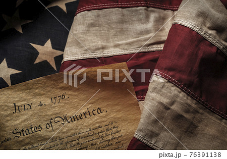 Close-up of Declaration of Independence resting on American flag 76391138