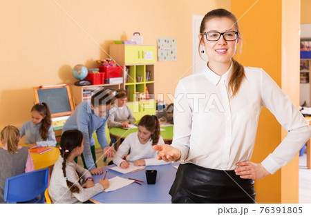 Woman teacher in classroom Woman teacher in classroom 76391805