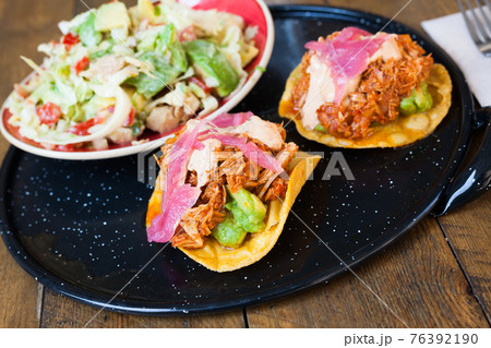 Image of tasty chicken salad with avocado and tuna tostada 76392190