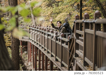 Asian handsome man trekking, climbing autumn mountain Asian handsome man trekking, climbing autumn mountain 76393523