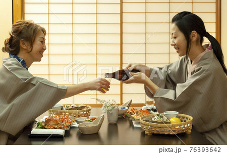 旅館でお酌をし合う浴衣の母娘 旅館でお酌をし合う浴衣の母娘 76393642