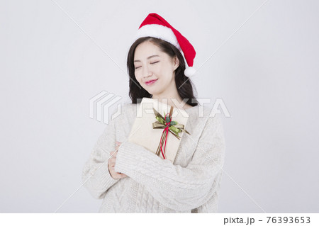 Asian female model with long hair wearing Santa hat, winter Christmas beauty promotion concept 76393653