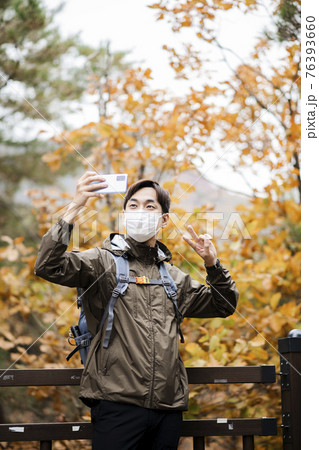 Asian handsome man with mask trekking, climbing autumn mountain 76393660