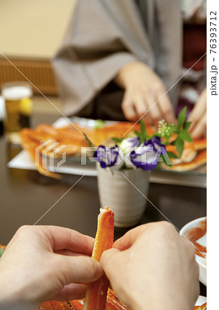 かにを食べる女性の手元 76393712