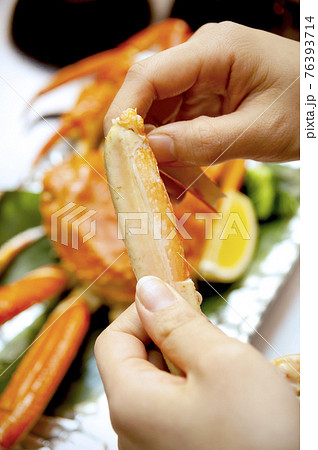かにを食べる女性の手元 76393714