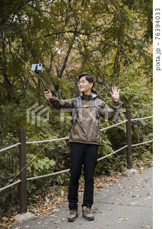 Asian handsome man trekking, climbing autumn mountain Asian handsome man trekking, climbing autumn mountain 76394033