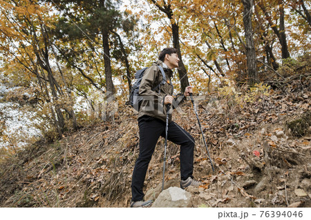 Asian handsome man trekking, climbing autumn mountain Asian handsome man trekking, climbing autumn mountain 76394046