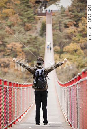 Asian handsome man with mask trekking, climbing autumn mountain 76394091