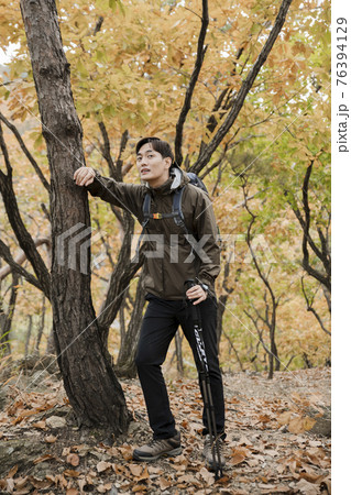 Asian handsome man trekking, climbing autumn mountain Asian handsome man trekking, climbing autumn mountain 76394129