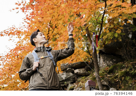 Asian handsome man with mask trekking, climbing autumn mountain Asian handsome man with mask trekking, climbing autumn mountain 76394146