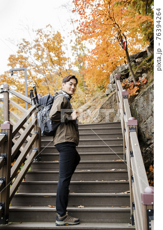 Asian handsome man with mask trekking, climbing autumn mountain 76394264