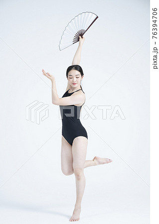contemporary Asian female dancer making move in white background 76394706