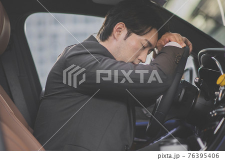 angry Asian male in suit sleeping, taking a nap in the car 76395406
