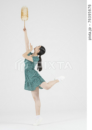 Asian female contemporary dancer holding cleaning tool Asian female contemporary dancer holding cleaning tool 76395676