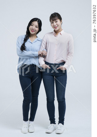 Smiling beautiful Asian woman holding arm of sister 76397632