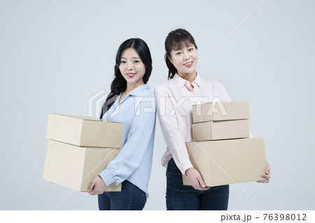 two Asian women, sisters carrying boxes 76398012