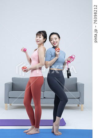 two fit Asian young women home training concept wearing sports top and leggings 76398212