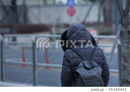 back shot of person on street in cold wather back shot of person on street in cold wather 76399493