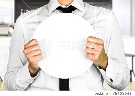 An empty plate held by a faceless waiter. Perfect shot for occupations, kitchen, no customers, pandemic, work. An empty plate held by a faceless waiter. Perfect shot for occupations, kitchen, no customers, pandemic, work. 76405643
