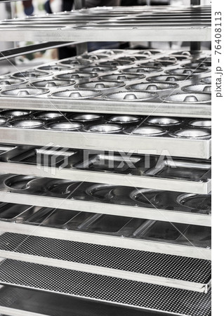 empty metal molds, trays and racks for baking bread and bakery products in a bakery empty metal molds, trays and racks for baking bread and bakery products in a bakery 76408113