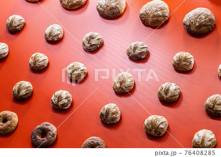 round loaves of bread hang on the red wall 76408285