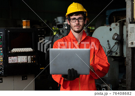 Skillful factory worker working with laptop computer to do procedure checklist . Skillful factory worker working with laptop computer to do procedure checklist . 76408682