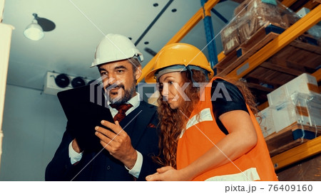 Warehouse senior manager discuss with worker in the storehouse Warehouse senior manager discuss with worker in the storehouse 76409160