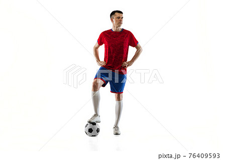 Young Caucasian soccer football player posing isolated on black background. 76409593