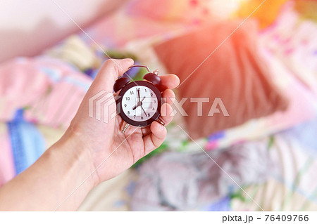 man in morning trying to turn off alarm clock in bedroom at home. wake up in morning time. man in morning trying to turn off alarm clock in bedroom at home. wake up in morning time. 76409766