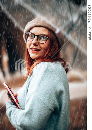 Beautiful red-haired girl with glasses and books for study look at the camera in the park Beautiful red-haired girl with glasses and books for study look at the camera in the park 76410208
