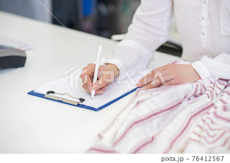 Female hands writing with pen on sheet Female hands writing with pen on sheet 76412567