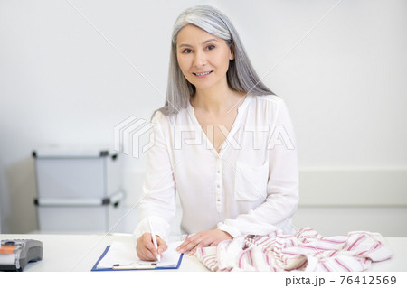 Good looking woman taking clothes for dry cleaning 76412569