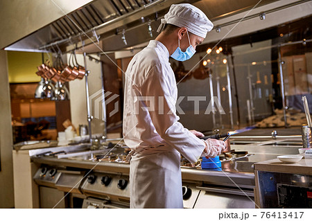 Cook using gas torch on a kitchen 76413417