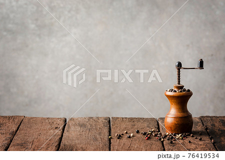 Retro pepper mill on wooden table Retro pepper mill on wooden table 76419534