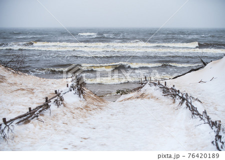 Baltic Sea beach is snowy in winter and there are big waves Baltic Sea beach is snowy in winter and there are big waves 76420189