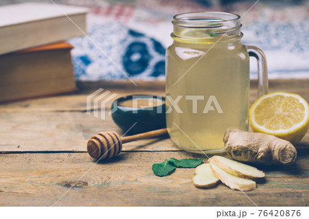 Hot drink with honey, lemon and ginger on wooden background. Concept of natural medicine. Winter or autumn drinks. 76420876