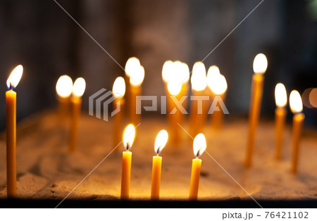 burning candles during a ceremony in a church burning candles during a ceremony in a church 76421102
