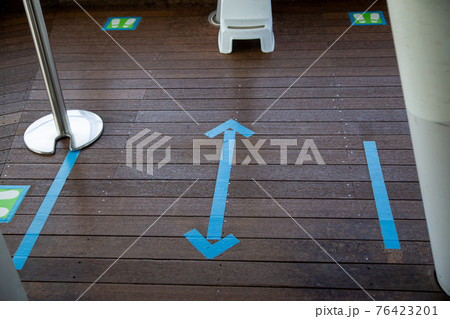 床に貼られたブルーのソーシャルディスタンス表示のテープ 床に貼られたブルーのソーシャルディスタンス表示のテープ 76423201