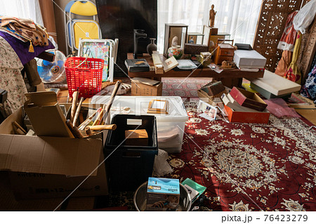 遺品整理中の古い家の散らかった洋室の中 76423279