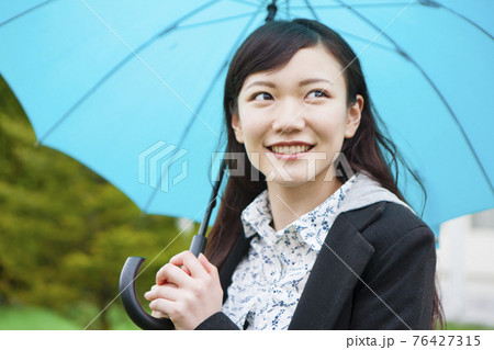 傘をさす女性 76427315