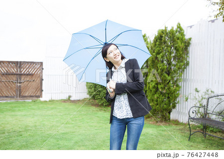 傘をさす女性 76427448