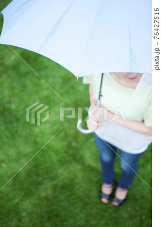傘をさす女性 76427516