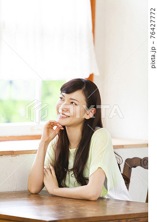 部屋で寛ぐ女性 76427772
