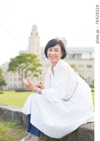 スマホ手に横浜 山下公園を楽しむさわやかミドルシニア女性 76428329