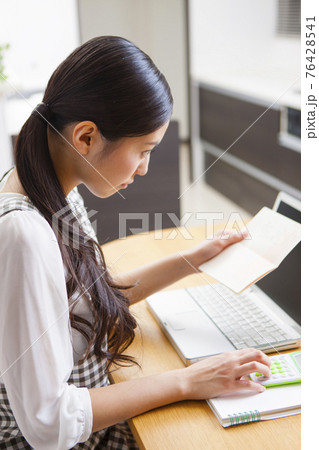 家計簿をつける女性 76428541